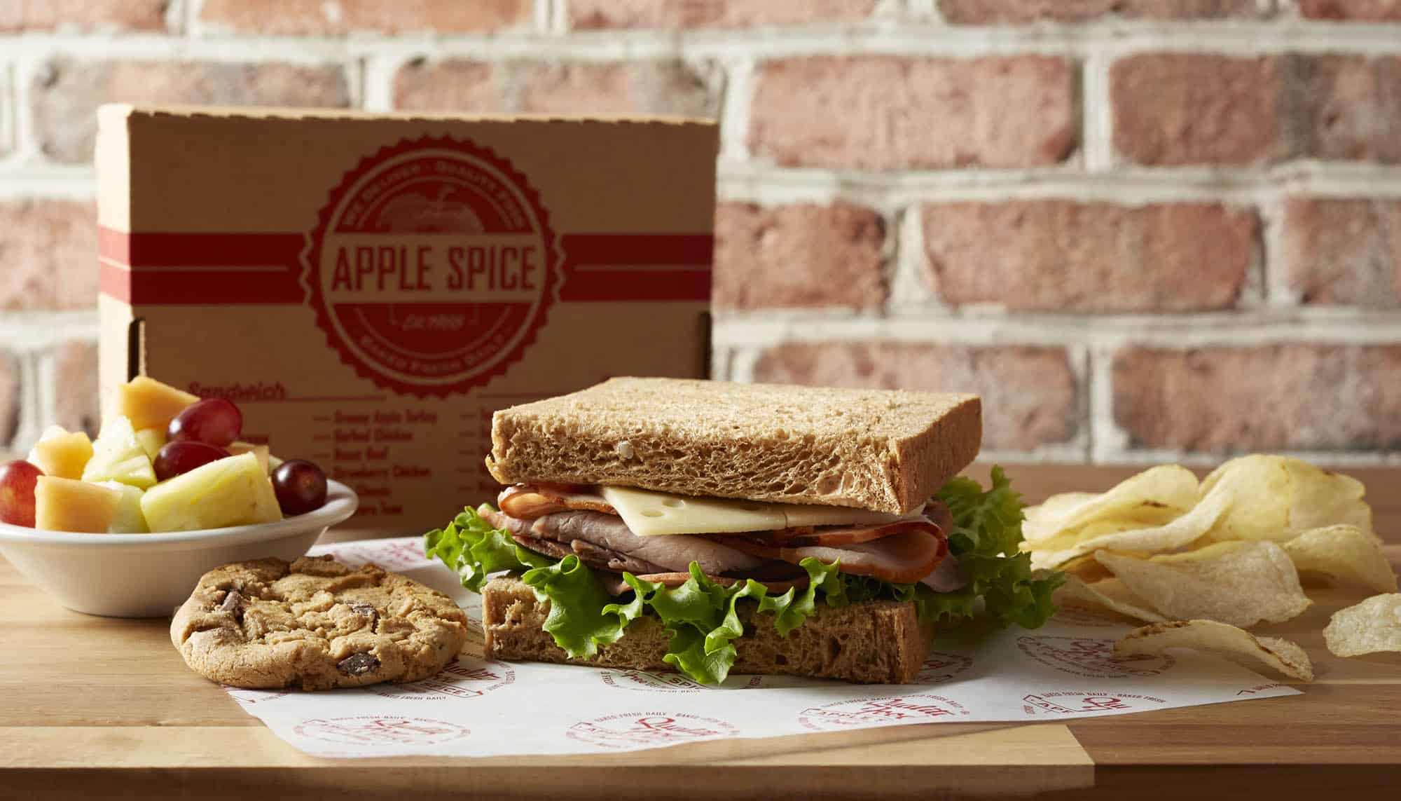 Apple Spice Sandwich and Snacks roast beef sandwich with chips, cookie, and fruit