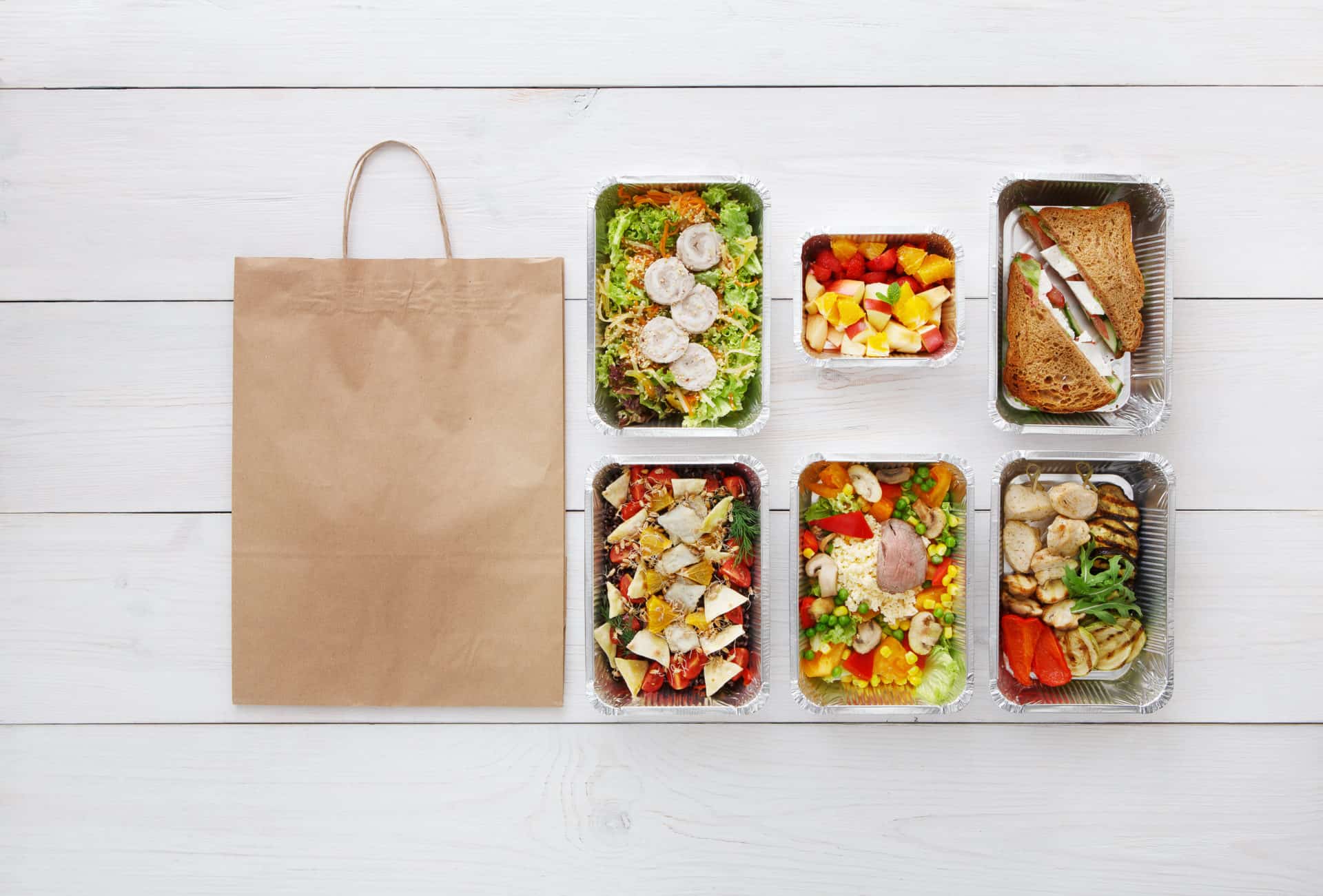 Healthy food take away in boxes, top view at wood Healthy food delivery, daily meals and snacks.