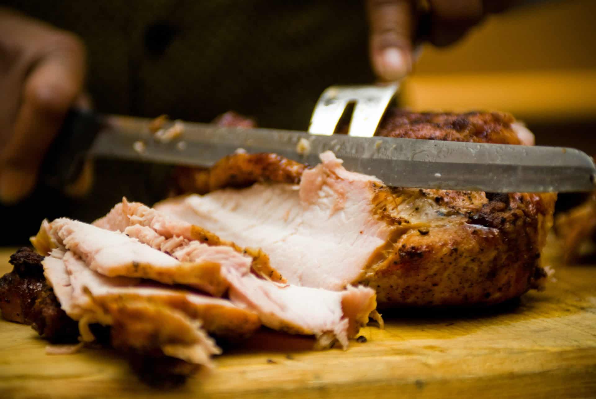 Cutting meat Man cutting meat to serve on a wooden board