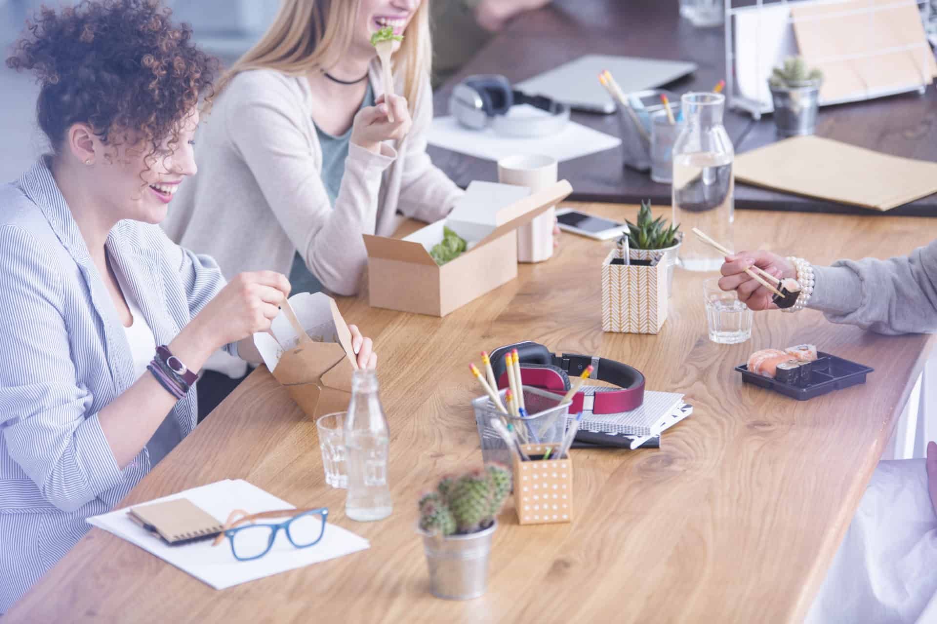 Desk with office supplies People eating lunch by wooden desk with office supplies and headphones
